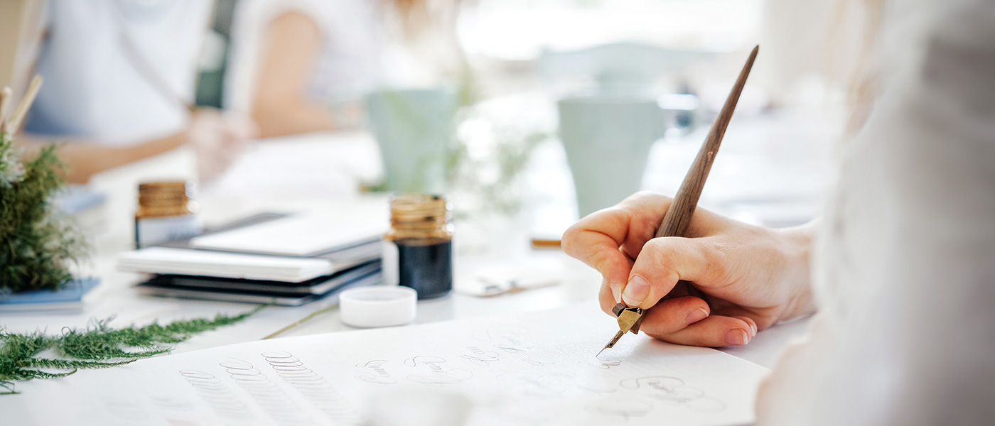 Woman writing with nib pen calligraphy