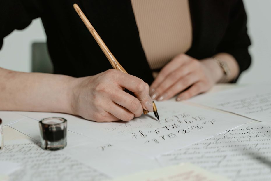 mage of a young girl focused and immersed in the art of calligraphy. She holds a pen poised over paper, her concentration evident in her posture. The delicate strokes and curves of her letters showcase her dedication to practicing the craft.