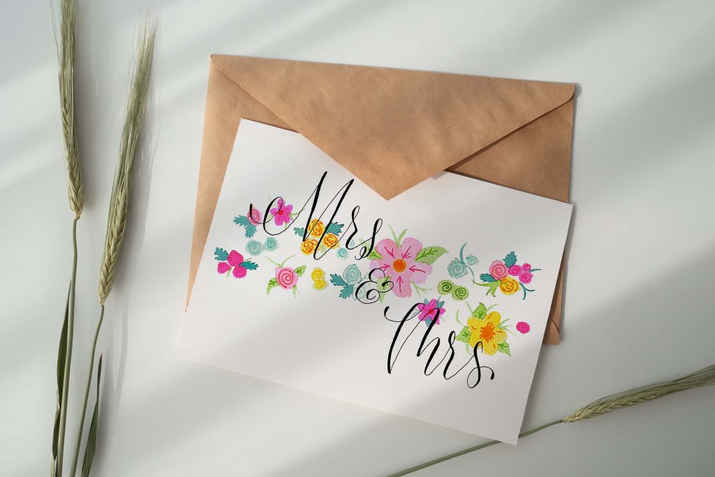 A mock-up of a handcrafted wedding card with vibrant and eye-catching colors. The card features beautiful watercolor floral illustrations, creating an elegant look.